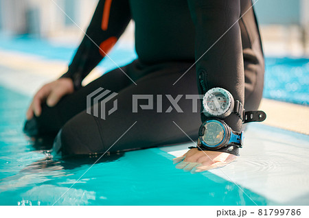 Male diver in scuba gear sitting at the poolside Male diver in scuba gear sitting at the poolside 81799786