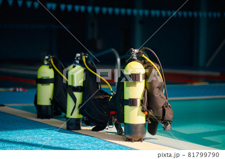 Three oxygen tanks at poolside, diving equipment 81799790