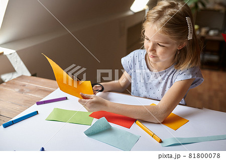Little girl cuts colored paper, kid in workshop 81800078