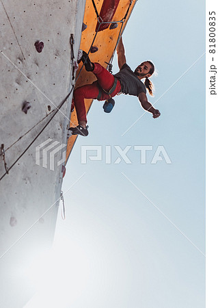 Young man professional rock climber practicing at training center in sunny day, outdoors. Concept of healthy lifestyle, activity Young man professional rock climber practicing at training center in sunny day, outdoors. Concept of healthy lifestyle, activity 81800835
