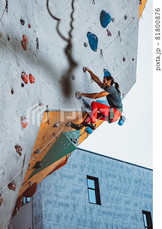 Young man professional rock climber practicing at training center in sunny day, outdoors. Concept of healthy lifestyle, tourism, nature, motion. 81800876