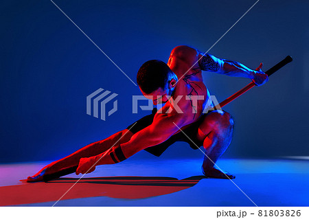 athlete men silhouette with stick training karate using sports tool in studio on colorfull lights background 81803826