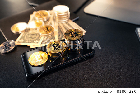 Stacked bitcoins grow on the desk. Stacked bitcoins grow on the desk. 81804230
