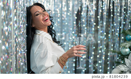Sexy brunette holding a glass of champagne. Woman wishes a happy christmas 81804239