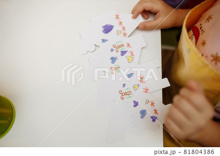 a child in training at home during quarantine makes origami out of paper. children's creativity. hands close up a child in training at home during quarantine makes origami out of paper. children's creativity. hands close up 81804386