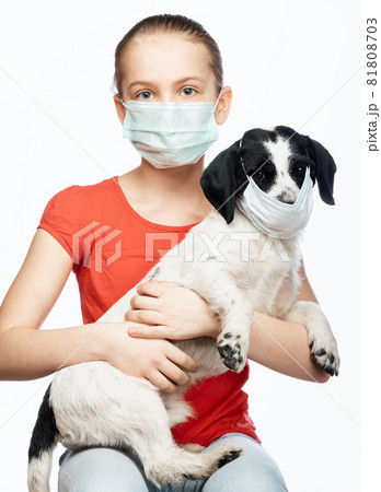 Child and dog wearing surgical masks portrait - measures against transmission of coronavirus disease 81808703