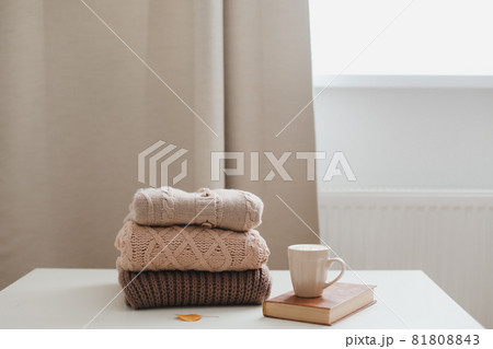 cozy comfortable autumn and winter home atmosphere and still life with a cup, candle, book and sweaters 81808843