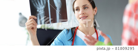 Doctor examines patient hand injury on an X-ray Doctor examines patient hand injury on an X-ray 81809295
