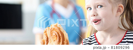 Little girl eating sweet confection on background of doctor Little girl eating sweet confection on background of doctor 81809296