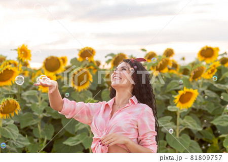 Cute brunette woman blowing soap bubbles. Cute brunette woman blowing soap bubbles. 81809757