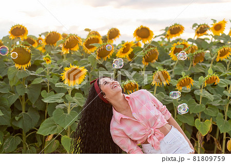 Cute brunette woman blowing soap bubbles. Cute brunette woman blowing soap bubbles. 81809759