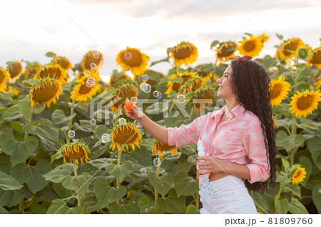 Cute brunette woman blowing soap bubbles. Cute brunette woman blowing soap bubbles. 81809760