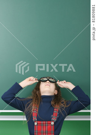 Schoolgirl near green school board. Schoolgirl near green school board. 81809881