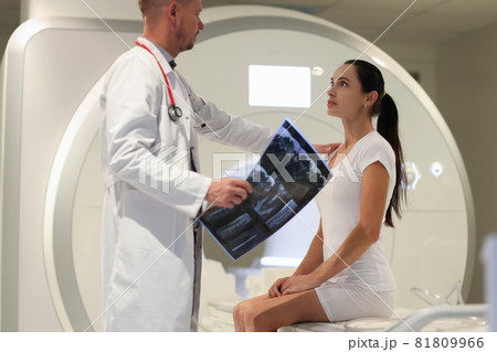 Male doctor explaining to female patient result of MRI examination in clinic 81809966