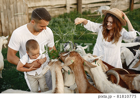Family spending time together outside with a goat 81810775