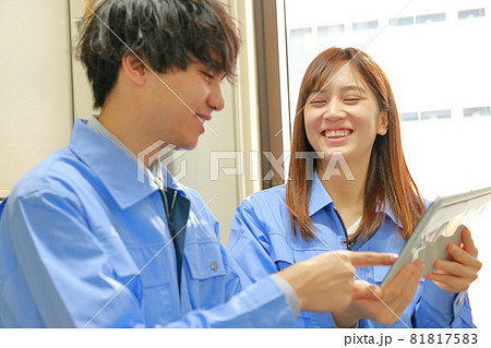 タブレットを使い笑顔で打ち合わせするエンジニア男女2 タブレットを使い笑顔で打ち合わせするエンジニア男女2 81817583