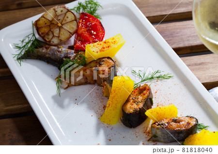 Tasty baked rainbow trout steaks with potatoes and greens on white plate Tasty baked rainbow trout steaks with potatoes and greens on white plate 81818040