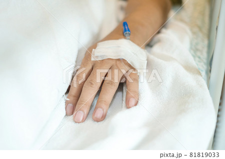 Focus on the hands of the male patient lying on the hospital bed. ready with an injection line or give intravenous medication Focus on the hands of the male patient lying on the hospital bed. ready with an injection line or give intravenous medication 81819033
