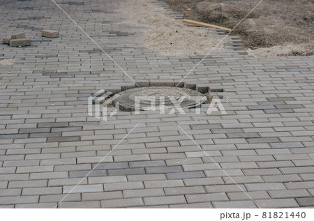Gray sidewalk with sewer manhole. Repair and restoration work. Town Square, reconstruction. Construction Industry. Architecture. 81821440