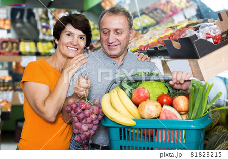 Positive family standing with basket with vegan products 81823215