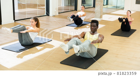 Sporty people doing pilates exercises in fitness studio Sporty people doing pilates exercises in fitness studio 81823359