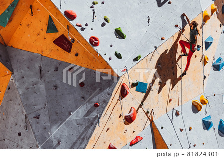 One Caucasian man professional rock climber practicing alone at training center in sunny day, outdoors. Concept of healthy lifestyle, tourism, nature, motion. One Caucasian man professional rock climber practicing alone at training center in sunny day, outdoors. Concept of healthy lifestyle, tourism, nature, motion. 81824301
