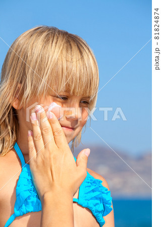 Mother applying sunscreen on her childs face 81824874