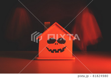 Ghosts fly around the house with an evil smile with a bloody tint. Halloween holiday. 81824980