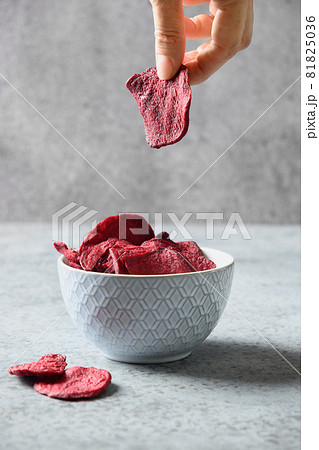 Vegetable vegan beetroot vegan chips in hand. 81825036