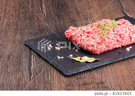 Minced meat on a stone board with thyme and spices. 81825603