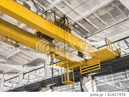 Part of an overhead building equipment crane in the background of an industrial workshop Part of an overhead building equipment crane in the background of an industrial workshop 81827956