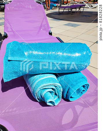 Close-up of bright blue towels on a chaise longue wrapped in stretch film, security measures against covid during a hotel stay, security from covid Close-up of bright blue towels on a chaise longue wrapped in stretch film, security measures against covid during a hotel stay, security from covid 81828228
