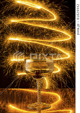 Glass of champagne on streaks of sparks background for New Year and Christmas Glass of champagne on streaks of sparks background for New Year and Christmas 81829442