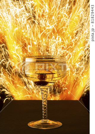 New Year and Christmas image of champagne glass on blast of sparks background New Year and Christmas image of champagne glass on blast of sparks background 81829443