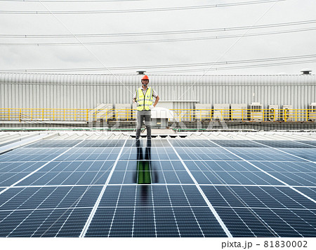 male engineer checks a photovoltaic (solar) plant and uses a recording tablet. mechanic in protective helmet. Man in uniform holding tablet.. male engineer checks a photovoltaic (solar) plant and uses a recording tablet. mechanic in protective helmet. Man in uniform holding tablet.. 81830002