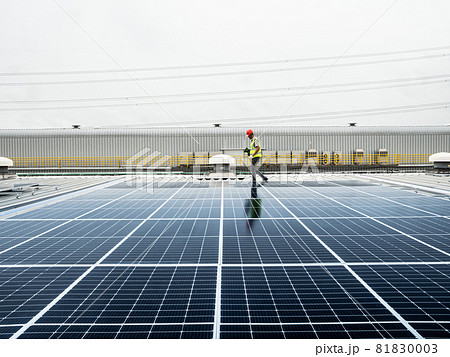 male engineer checks a photovoltaic (solar) plant and uses a recording tablet. mechanic in protective helmet. Man in uniform holding tablet.. male engineer checks a photovoltaic (solar) plant and uses a recording tablet. mechanic in protective helmet. Man in uniform holding tablet.. 81830003