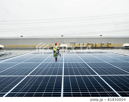 male engineer checks a photovoltaic (solar) plant and uses a recording tablet. mechanic in protective helmet. Man in uniform holding tablet.. male engineer checks a photovoltaic (solar) plant and uses a recording tablet. mechanic in protective helmet. Man in uniform holding tablet.. 81830004