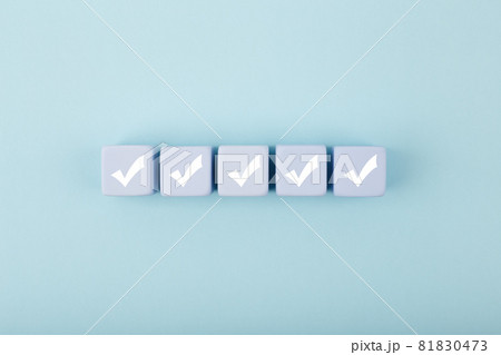 Five white checkmarks on white cubes against bright pastel blue background Five white checkmarks on white cubes against bright pastel blue background 81830473