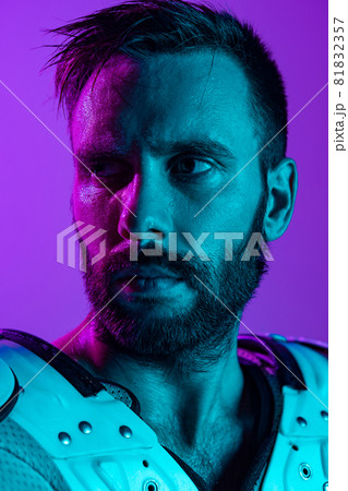 Close-up portrait of male american football player isolated over studio purple background in neon 81832357
