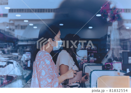 Woman in protective mask paying bill at cashier counter in market shop. 81832554