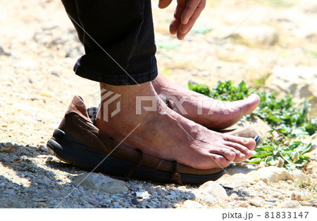 a man walks barefoot along a sandy beach on the shores of the mediterranean sea a man walks barefoot along a sandy beach on the shores of the mediterranean sea 81833147