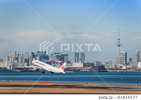 羽田空港第2ターミナルを離陸したjal機と東京スカイツリー の写真素材