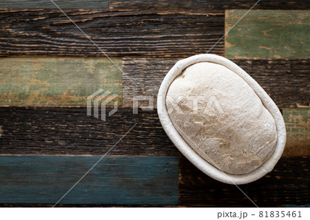 Bread dough in a rattan basket on a table made of wood 81835461