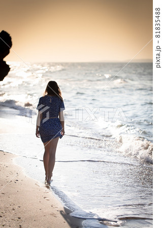 a girl walking on the beach at sunset a girl walking on the beach at sunset 81835488