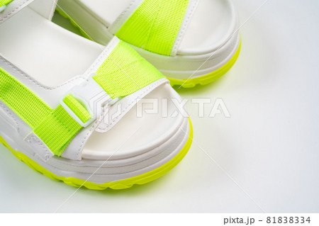 fashionable white with green sandals on the platform on a white background. fashionable white with green sandals on the platform on a white background. 81838334