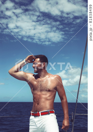 Young man sailing his boat on the open ocean Young man sailing his boat on the open ocean 81838499