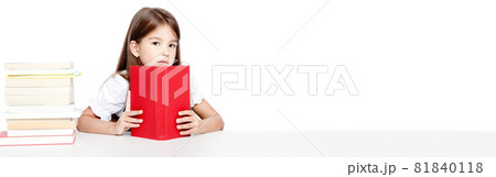 Young cute girl sitting at the table and reading a book 81840118