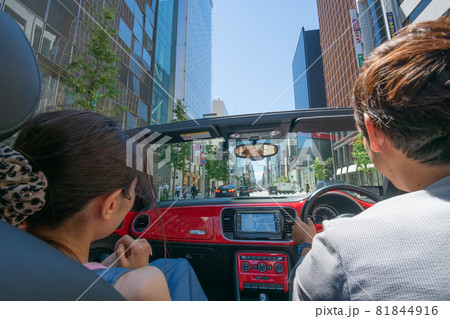オープンカー全開で都会をデートするカップル オープンカー全開で都会をデートするカップル 81844916
