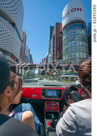 オープンカーで都会のド真ん中をデートするカップル オープンカーで都会のド真ん中をデートするカップル 81845360