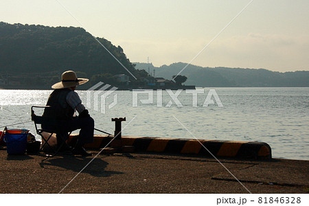 岸壁の麦わら帽子の釣り人の写真素材